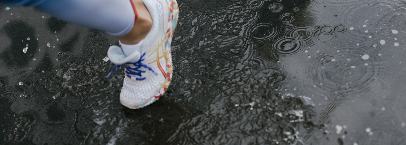 West End Runners - woman running through a puddle